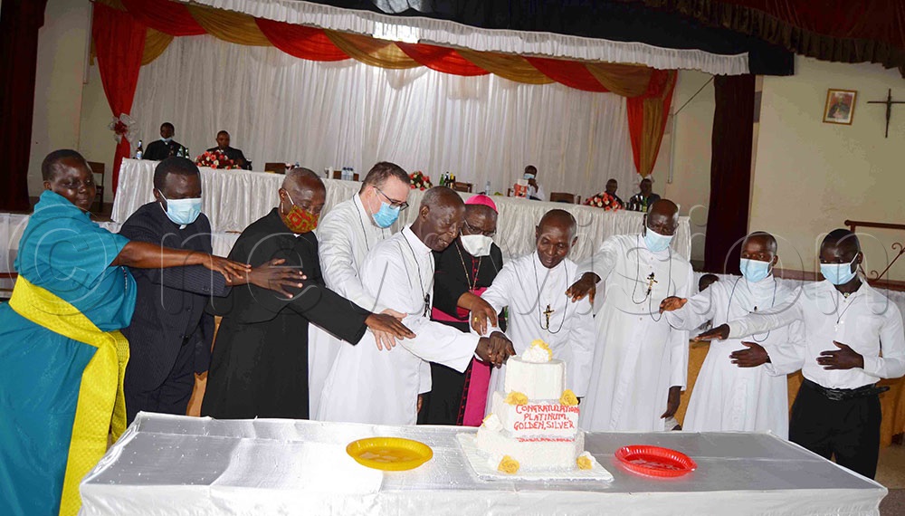 Archbishop-designate Paul Ssemogerere (wearing a skull-cap) cutting cake with some of the jubirarian and newly-profesed Brothers of Christian instruction during the Brothers' professions celebration function at St. Mary's College Kisubi, in Wakiso district on New Year's Day. (All Photo by Mathias Mazinga)