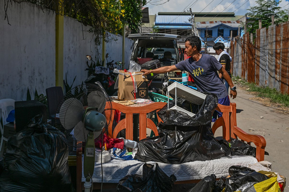 A resident gathers belongings after a 7.8 magnitude earthquake in General Santos City on June 9, 2026. A 7.8-magnitude earthquake in the southern Philippines on June 8 killed at least 35 people, according to provincial authorities, after toppling buildings and sparking tsunami warnings across the region. (Photo by Jam STA ROSA / AFP)