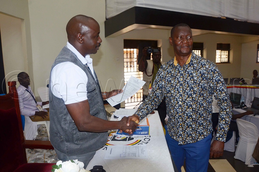 The returning officer of Wakiso district Tolbert Musinguzi (Left) shaking hands with LC5-elect of Wakiso district Ian Kyeyune (Right) at the Wakiso district headquaters on Friday. (Photo by Job Nantakiika)