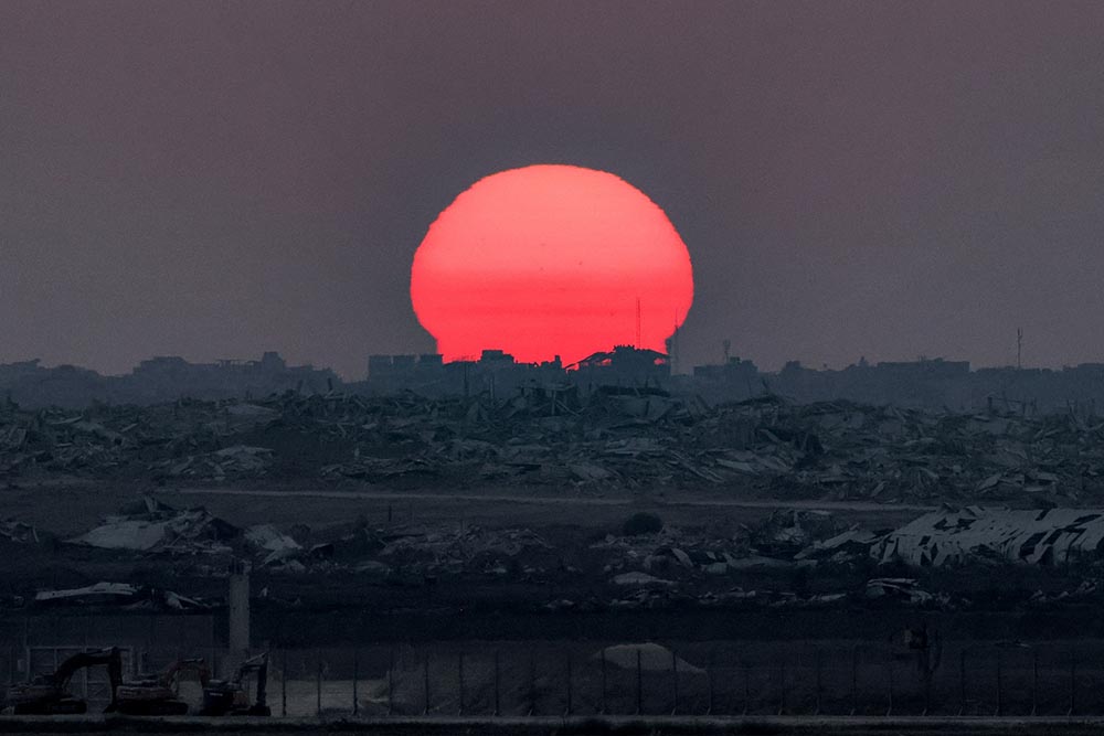 The sun sets over the Gaza Strip as pictured from a position along the border with the besieged Palestinian territory in southern Israel on August 10, 2025. (AFP Photo)