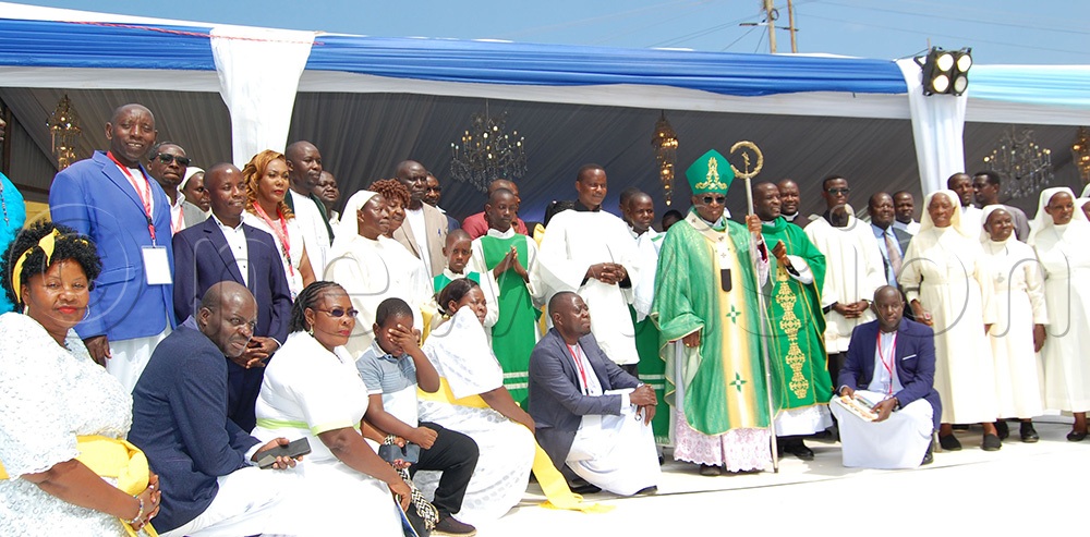 Archbishop Paul Ssemogerere (holding a crosier) shares a photo-moment with some of the consecrated religious and sub-parishioners of Namugonde Catholic sub-parish during the church's 80th anniversary celebration on Sunday, June 28, 2026. (Photo by Mathias Mazinga)