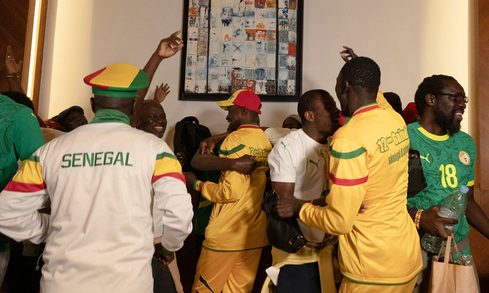 Senegalese supporters who were granted a royal pardon in Morocco dance as they arrive at Blaise Diagne International Airport in Ndiass, Senegal on May 24, 2026, after being held in Morocco since the Africa Cup of Nations final. (Photo by SEYLLOU / AFP)