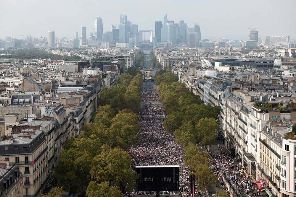 A photograph taken from the roof of the Arc de Triomphe shows worshippers gathered along the Avenue de la Grande Armee, with the La Defence district in the background, to attend a solemn outdoor mass celebrated by Pope Leo XIV at Place de la Concorde, central Paris, on September 26, 2026 on the second day of his visit to France. (AFP)