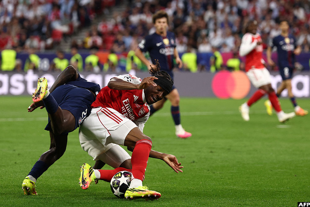 Arsenal's midfielder Noni Madueke went down inside the PSG area under close attentions from Nuno Mendes