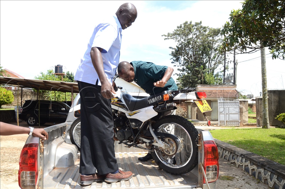 IGG officials loading the motorcycle onto a government vehicle at the Arua Office 