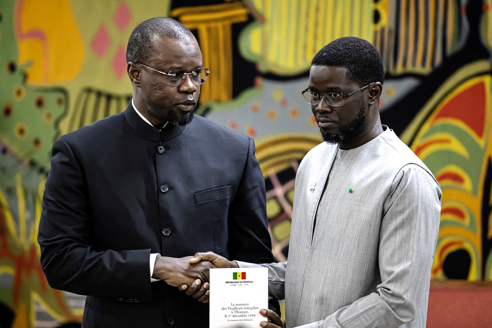 Ousmane Sonko (L) hands over to Senegal President Bassirou Diomaye Faye (R) and official report during a ceremony at the Presidential Palace in Dakar, on October last year when he was serving as prime minister. (Credit: AFP)