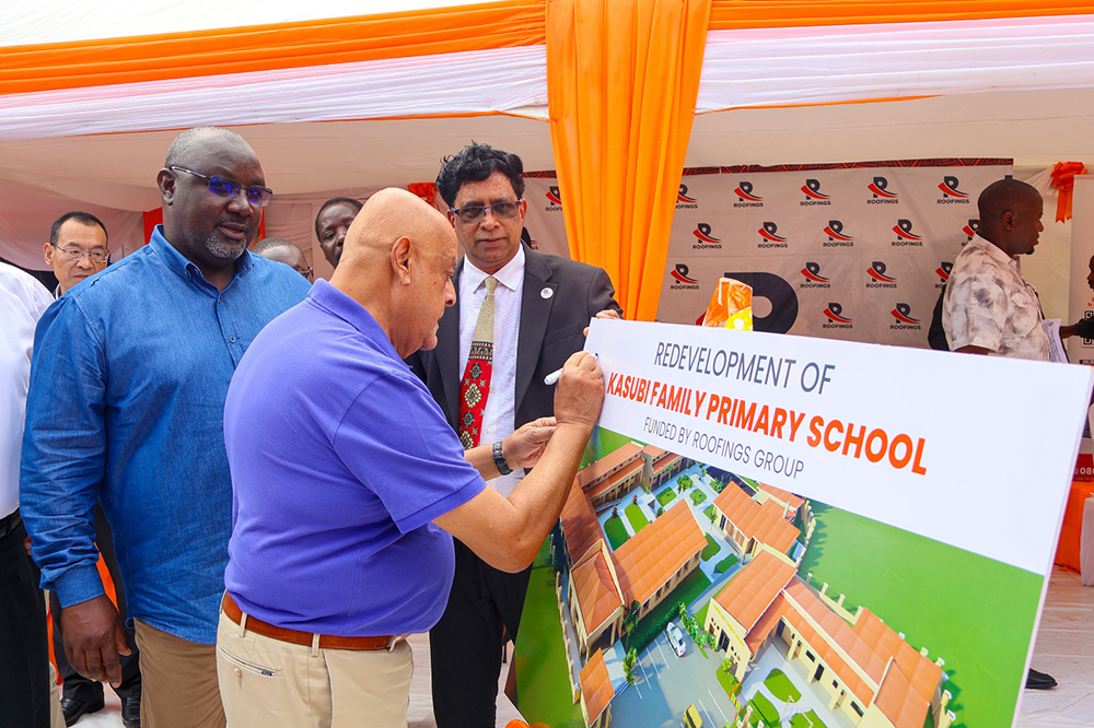 Roofings Group chairman Dr Lalani pens a signature on the artists&rsquo; impressions of the modern school as Benon Kigenyi, KCCA deputy executive director takes a close look. (Courtesy)