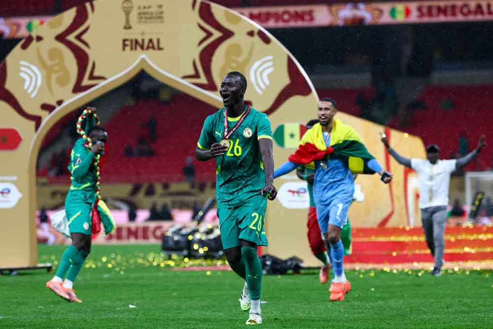 Senegal's midfielder #26 Pape Gueye (C) and his teammates celebrate their victory at the end of the Africa Cup of Nations (CAN) final football match against Morocco at the Prince Moulay Abdellah Stadium in Rabat on January 18, 2026. (AFP Photo)