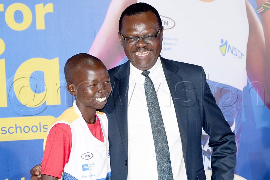 NSSF Managing Director Patrick Ayota (right) poses with Oreku Primary School's Pascal Ondia  during the launch of the NSSF Hills Run at Workers House. Photo by Michael Nsubuga