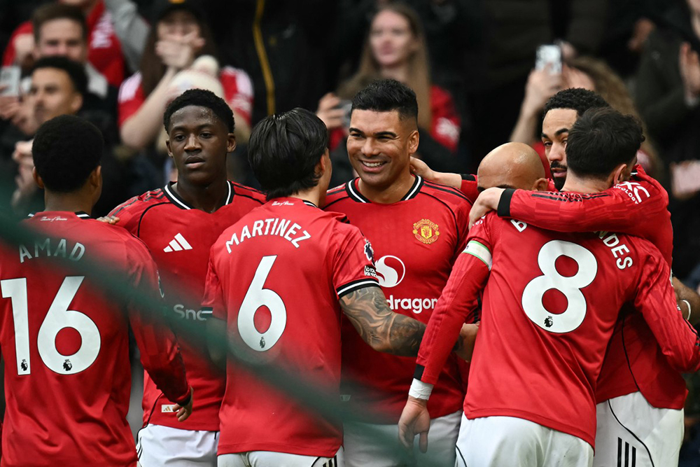 Manchester United's Brazilian midfielder #18 Casemiro (C) celebrates with teammates after scoring the team's first goal during the English Premier League football match between Manchester United and Fulham at Old Trafford in Manchester, north west England, on February 1, 2026. 