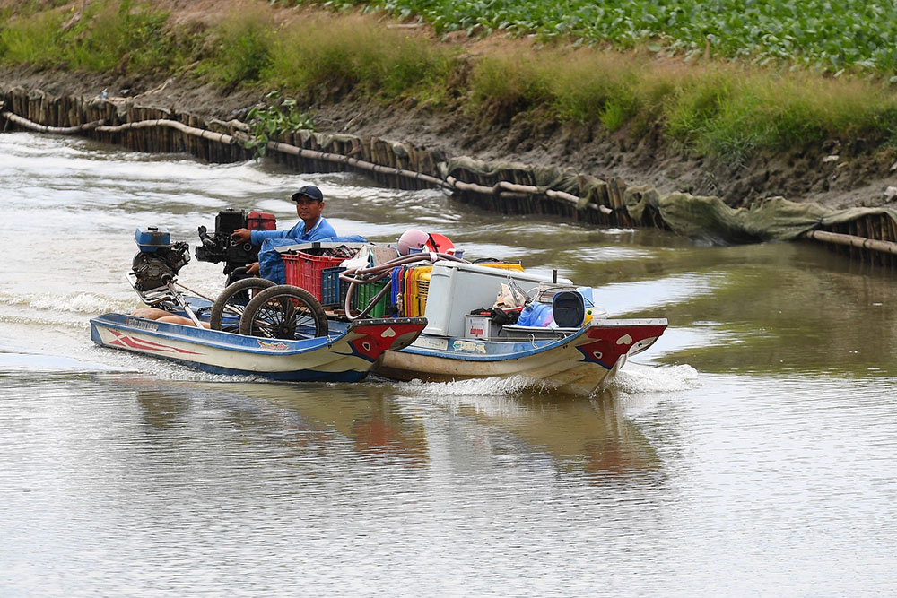 A man carries home appliances on a boat in a canal off the Song Hau river in Can Tho city of southern Vietnam's Mekong Delta on February 28, 2023. (All photos by AFP)