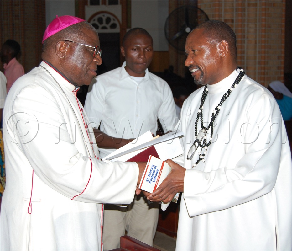 Archbishop Paul Ssemogerere (left) shares a moment with the Provincial Superior of the White Fathers for East Africa, Fr. Oswald Mallya (right) during the Memorial Lecture at Lubaga Cathedral.