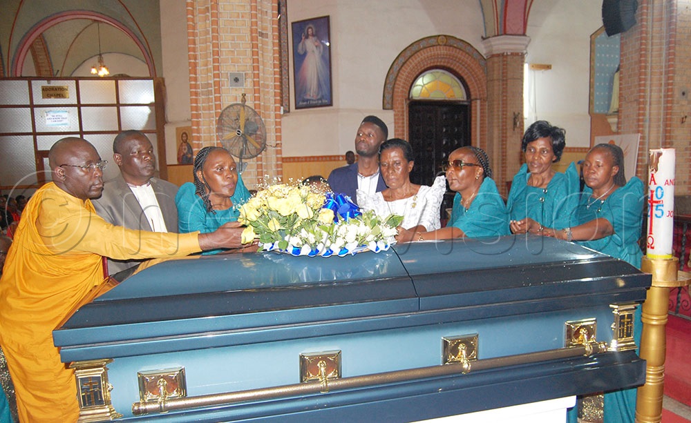 Chevalier Malokweza's children lay a wreath on the casket containing his remains. This was during the deceased's funeral mass at Lubaga Cathedral on Tuesday, August 19, 2025. (Credit: Mathias Mazinga)