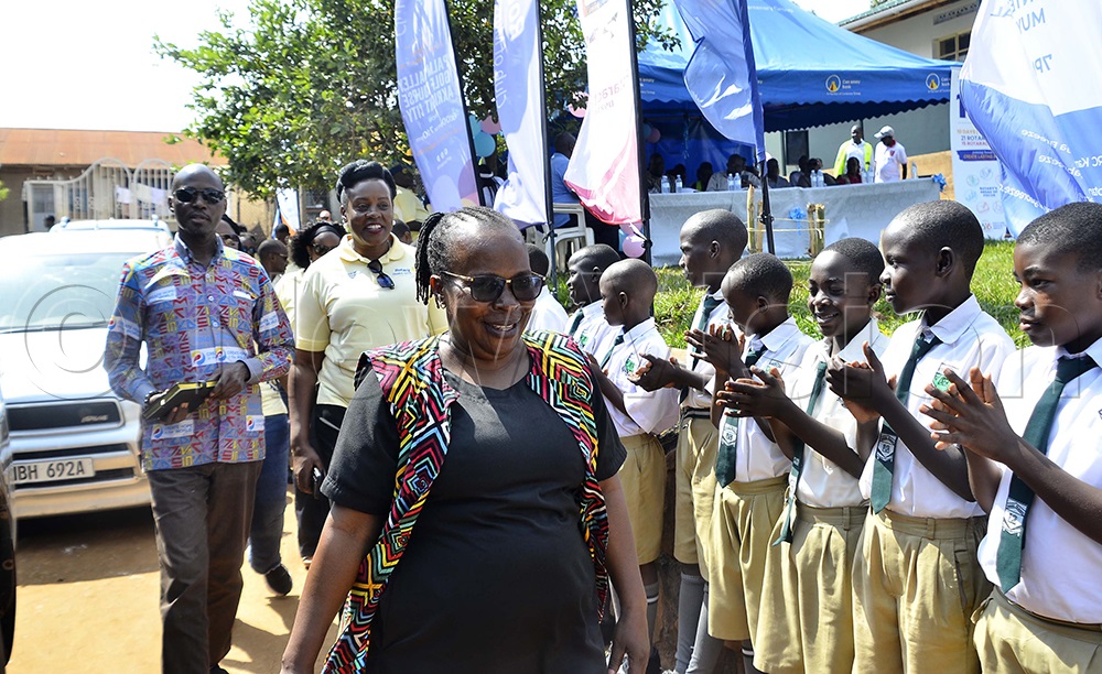 Children welcome Jalia Nakayiza, head teacher of Kansanga Primary School; Ken Mugisha, Past District Governor; and Beatrice Lugalambi, president of the Rotary Club of Muyenga, during the commissioning of the school library at Kansanga Primary School in Makindye Division on August 7, 2026. (Photo by Juliet Kasirye)