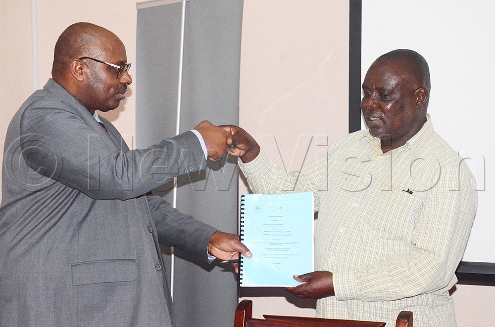 The Permanent Secretary at the Ministry of Local Government, Ben Kumumanya, hands over a signed contractors' agreement at the ministry's offices in Kampala on Wednesday, July 8, 2026. (Photo by Isaac Nuwagaba)