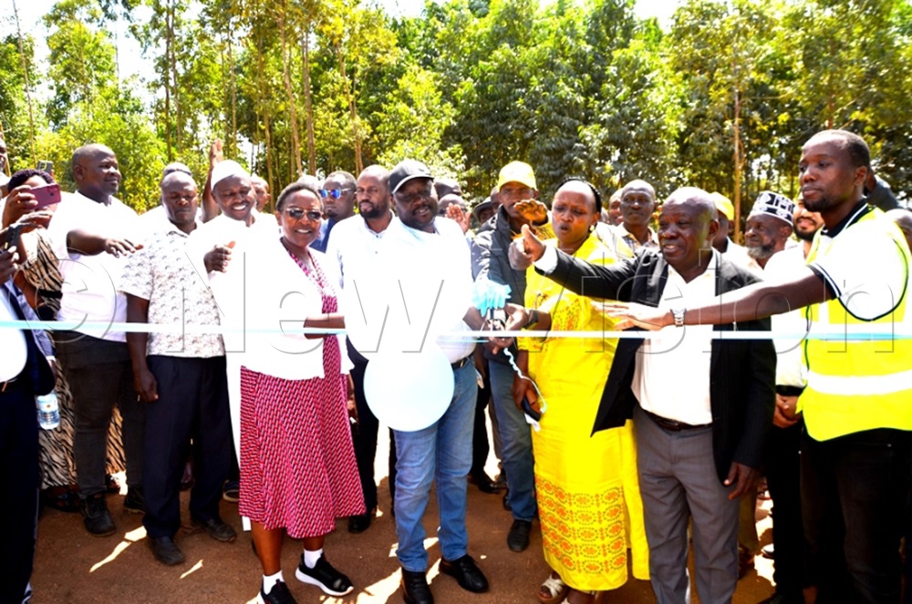 The designated State Minister for Microfinance, Shartsi Musherure (yellow dress); Mawogola North MP Godfrey Aine Kaguta; Sembabule District RDC Jane Frances Kagayi; and District Council Chairperson Patrick Nkalubo officiate at the sh9b water project in Sembabule District. (Photos by Dismus Buregyeya)