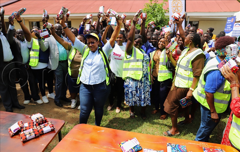 The Rotary members of Manyangwa Nakwero with Arua District leaders and Pupils of Ayelembe pose for a photo with sanitary pads after supporting the school