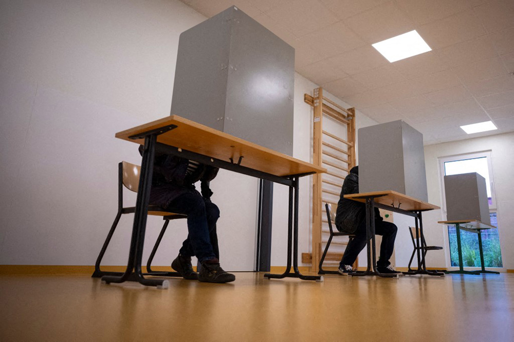 First voters sitting in a voting booth at the G&auml;nsebl&uuml;mchen daycare centre to cast their ballots in the Mecklenburg-Western Pomerania state election. (Photo by Philip Dulian / dpa Picture-Alliance via AFP)