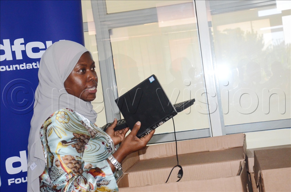  The Permanent Secretary of the Ministry of ICT and National Guidance Dr. Aminah Zawedde displaying one of the computers donated by DFCU at Nakawa ICT Hub.