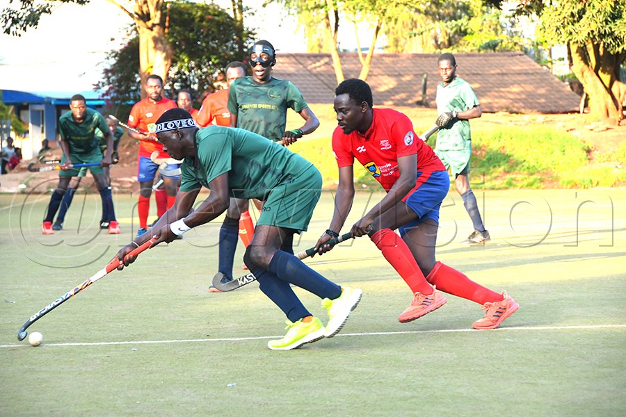 Wananchi striker Jackson Musinguzi (on the ball) takes on Kampala HC defender James Byakagaba during the Hockey Uganda Cup quarter-final at Lugogo. Photo: Silvano Kibuuka
