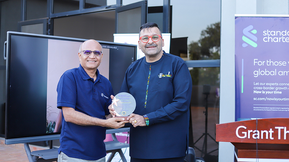 Grant Thornton Executive Chairman Anil Patel handing over a gift to Sanjay Rhougan, the chief guest and the CEO of Stanchart Bank Uganda. (Courtesy)
