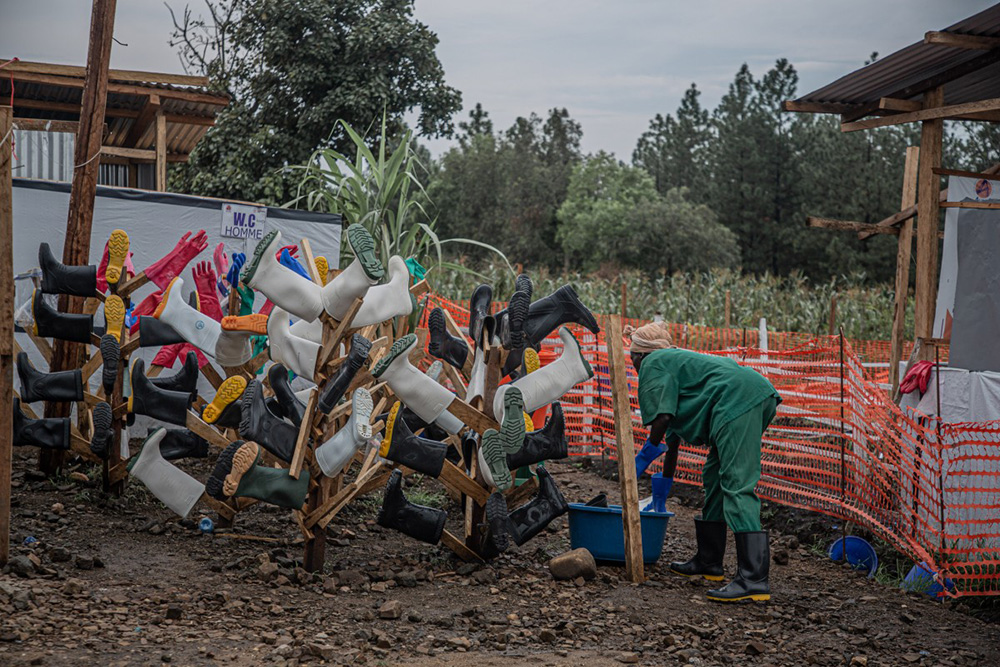 A hygiene worker cleans the boots of healthcare workers at the Rwampara Ebola Treatment Centre (ETC) in Bunia, Ituri, in the east of the Democratic Republic of Congo on July 13, 2026. (Photo by BENEDICTION MURHABAZI / AFP)