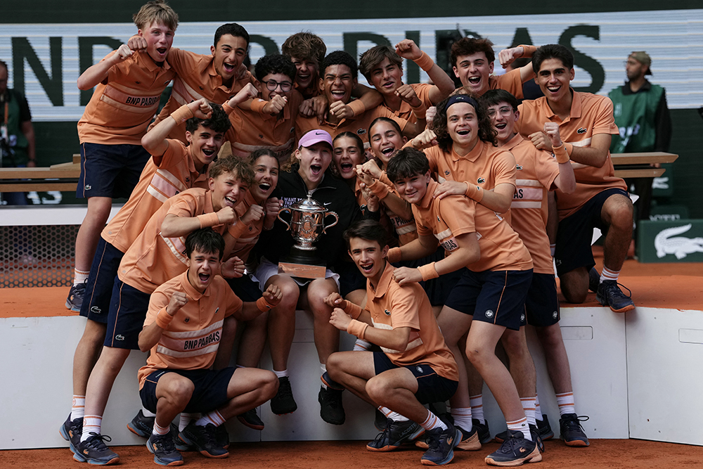 Russia's Mirra Andreeva poses with ball girls and ball boys after winning the French Open tennis tournament women's singles final match against Poland's Maja Chwalinska on day 14 of the French Open tennis tournament on Court Philippe-Chatrier at the Roland-Garros Complex in Paris on June 6, 2026. (AFP)