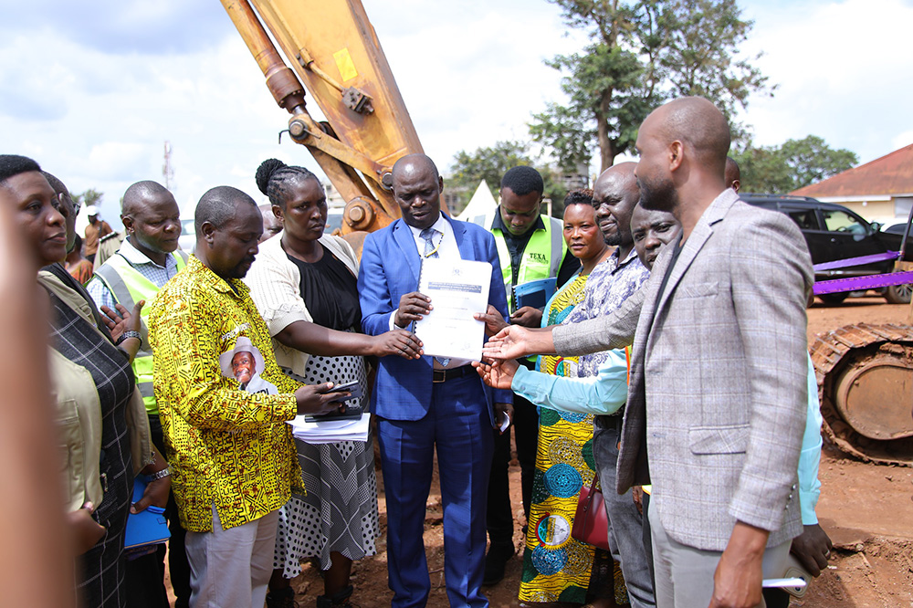 Local contractors receive documents from State Minister for Kampala, Kabuye Kyofatogabye (in suit), and the Under Secretary in the Ministry of Kampala, Monica Edemachu, during an event. (Courtesy photo)