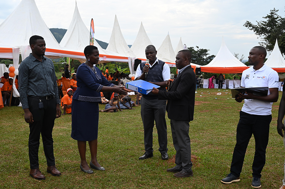James Kaahwa Programmes Director at world Vision handing over documents to the Chief administration officer of Kiboga District and other district officials. (Courtesy photo)