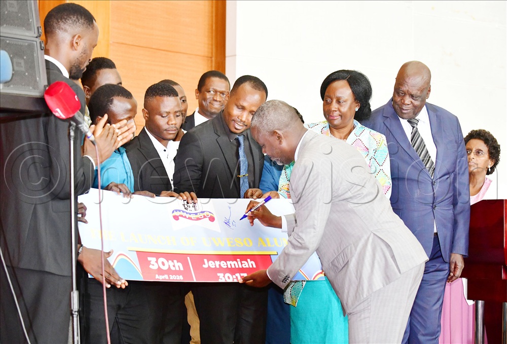 The Deputy Speaker of Parliament Rt. Hon. Thomas Tayebwa appending his signature on a dummy as he launched UWESO alumnai. Looking on second right is UWESO Chairperson Olive Birungi Lumonya and right is Hon. Peter Lokeris, Minister for Karamoja Affairs.