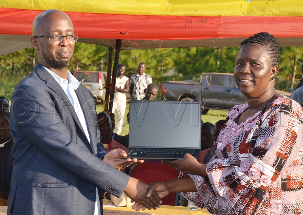 Dr Hatwib Mugasa, the Executive Director of NITA-Uganda (left), handing over a laptop to Janeth Phoebe Ayoo Obol, Woman MP, Gulu District. (Photo by Jackson Kitara)