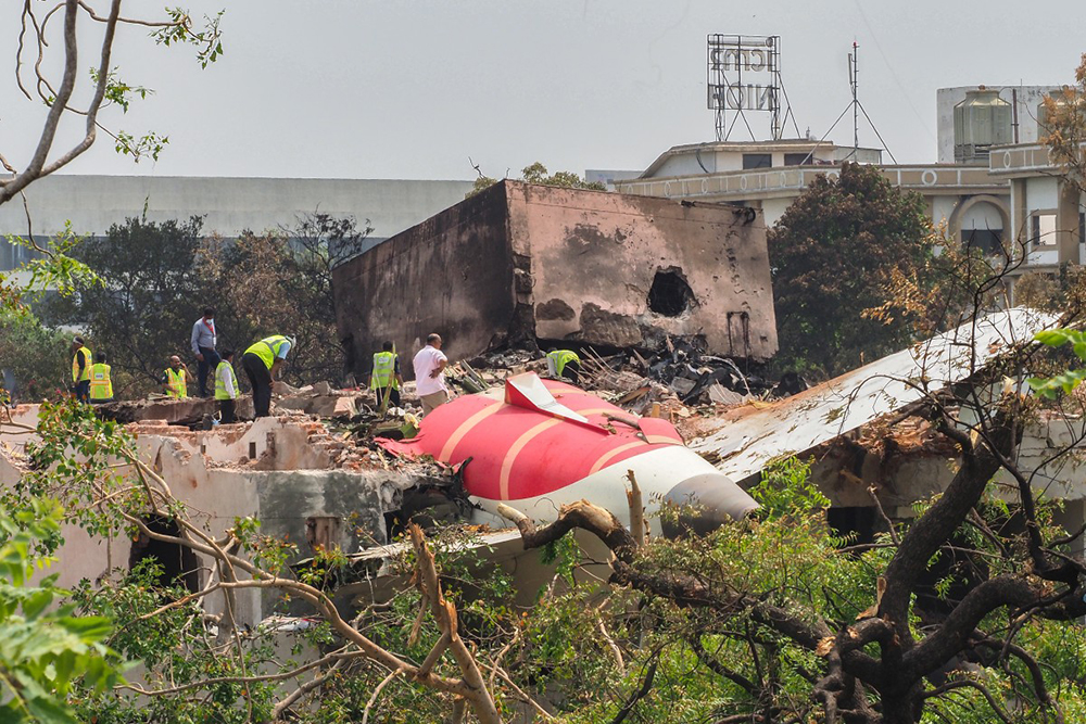 An investigation team inspects the wreckage of Air India flight 171 a day after it crashed in a residential area near the airport, in Ahmedabad on June 13, 2025. (Photo by Sam PANTHAKY / AFP)