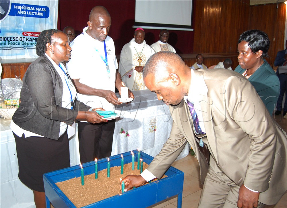 Lord Mayor Erias Lukwago  lights a candle in memory of the late Benedicto Kiwanuka.