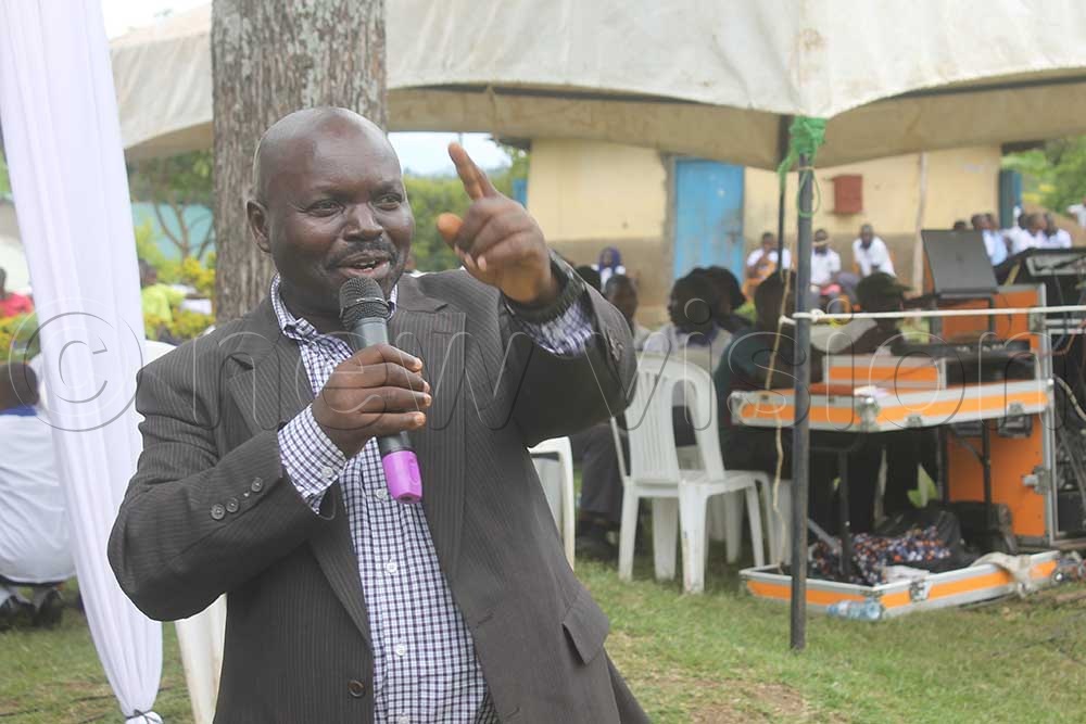 Lt. Maate Magwara, the Kasese deputy RDC (standing) while at Kuruhe High School calls upon parents to change their mindset, and utilize PDM funds effectively to solicit money to educate their children. (Credit: Samuel Amanyire)