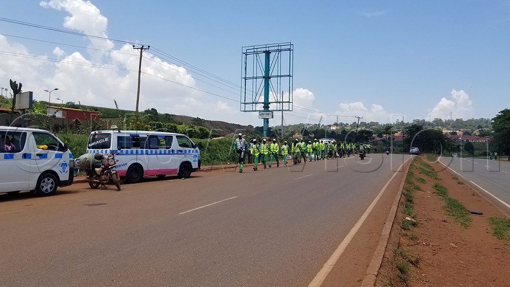 Walkers walking along the Jinja Kampala highway in Jinja City on Monday afternoon, entering the central region. (Photo by Leonard Mukooli)