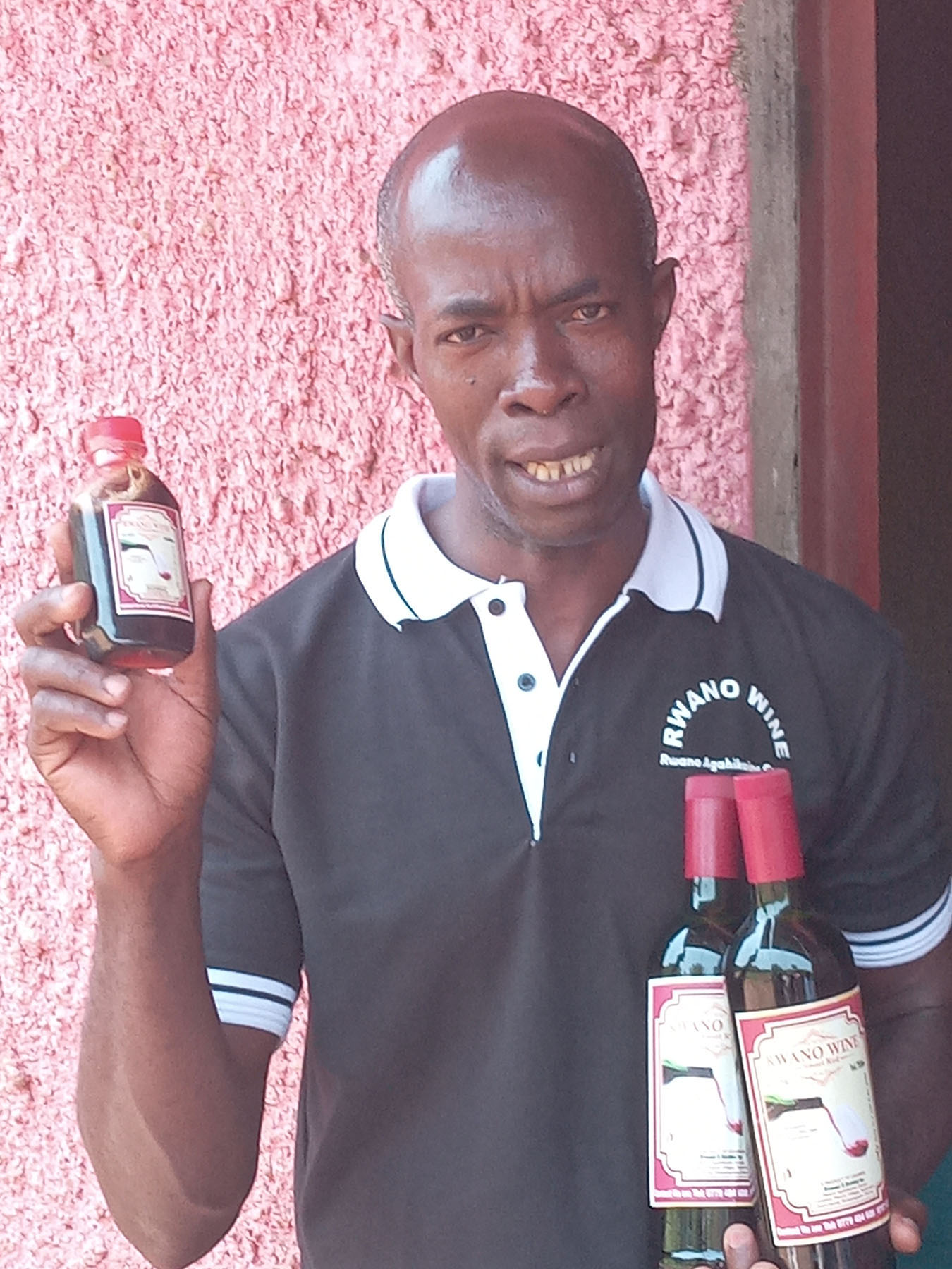 Moses Muzoora shows off some of wine products made from bananas by the farmers association. (Photo by Stephen Nuwagira)