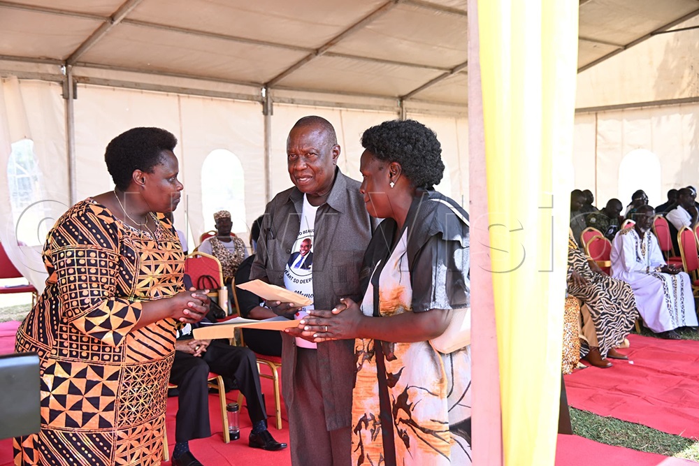 Alupo sharing with some of the children of late Etonu on the burial day. (Credit: Godfrey Ojore)