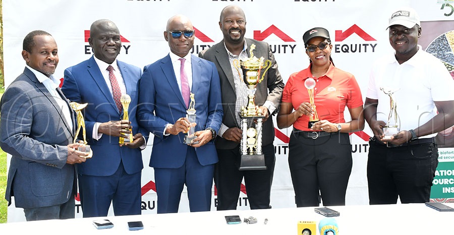 Claver Sserumaga (3rd left) the executive director of Equity Bank, tournament director Keneth Tumusiime (center) and the club chairman Herbert Kamuntu (left), NaCCRI director Titus Alicai (2nd left), Euqity's Clare Tumwesigye and club captain Timothy Lwanga parade some of the trophies to be competed for during the launch of the fifth edition of the Equity-NARO Namulonge Golf Open at the Mary Louise Simkins Memorial Golf Club. Photo by Michael Nsubuga