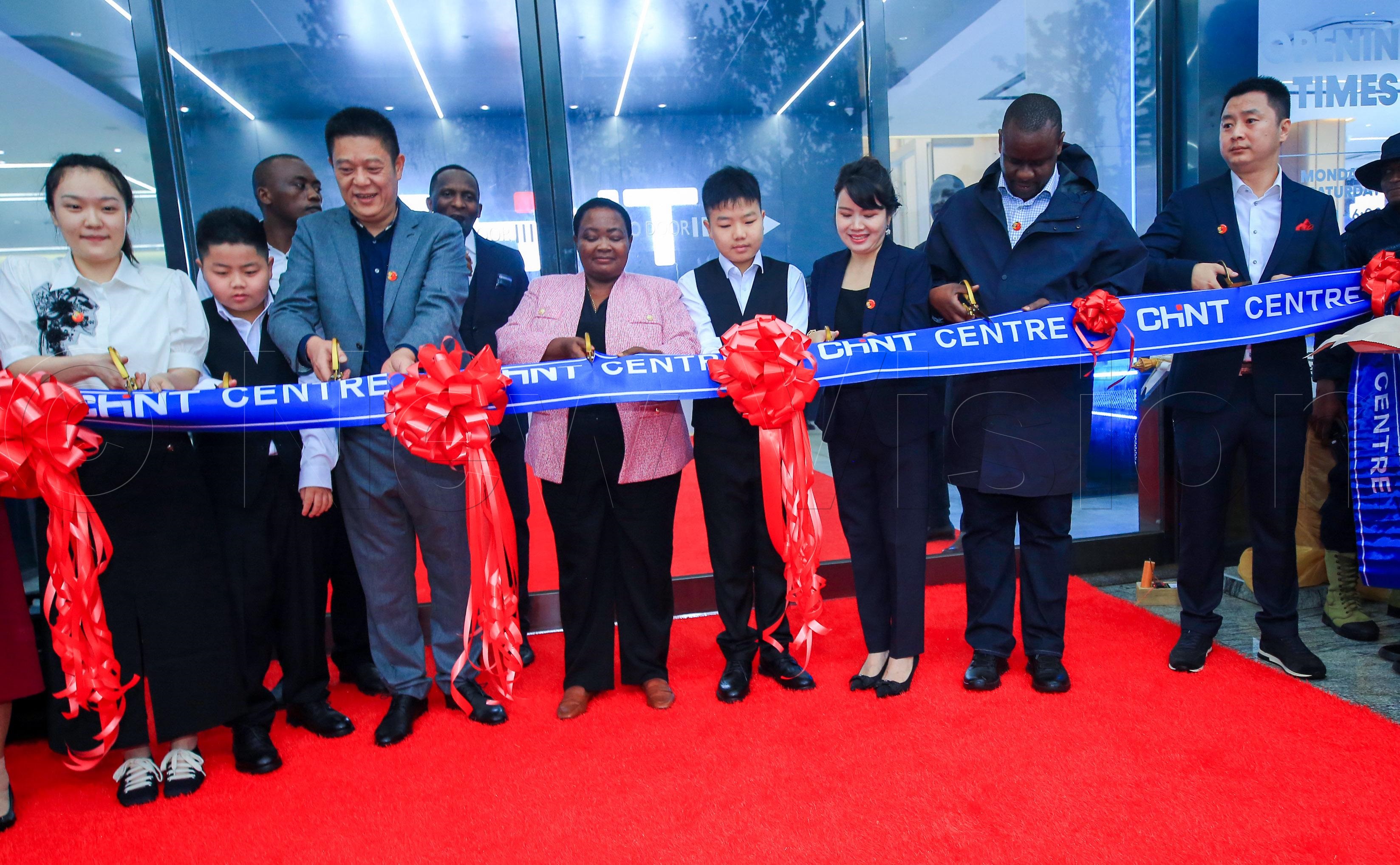 The Prime Minister joined by Hon. Balaam Barugahara and CHINT electrical shop officials in cutting the ribbon.