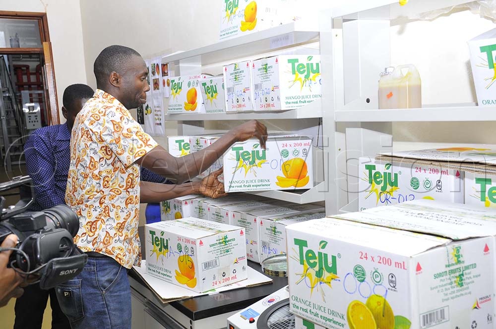 A Worker arranges boxes of finished products made out of mangoes and oranges ready for the  market in Soroti City. (Credit: Wilfred Sanya) 