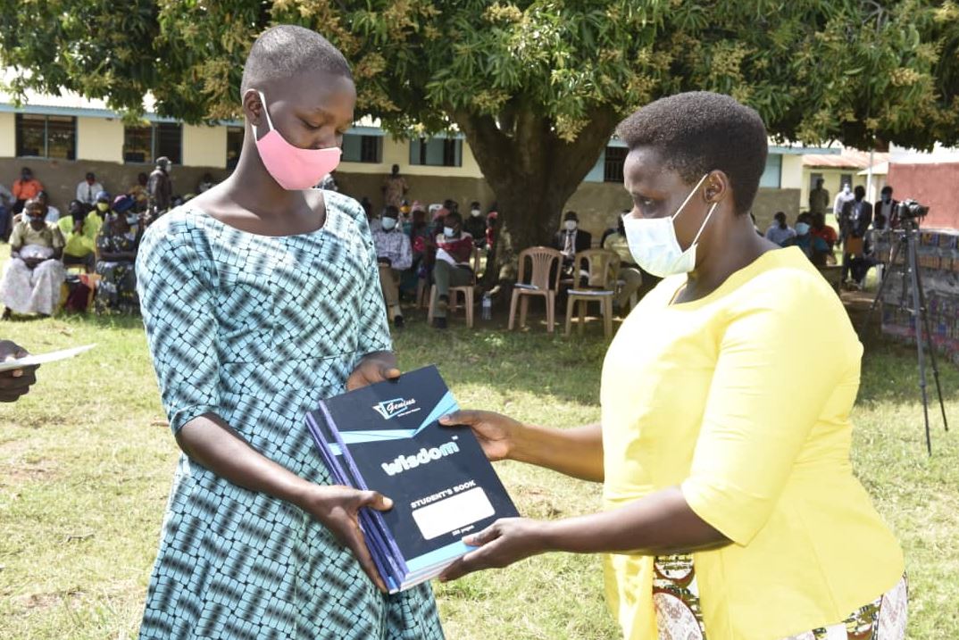 The Vice President hands over scholastic items to one of the 32 students.