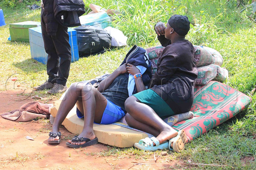 Some of the students stranded with their property as they waited to be picked by their parents after the school was closed. (Photo by Henry Nsubuga)