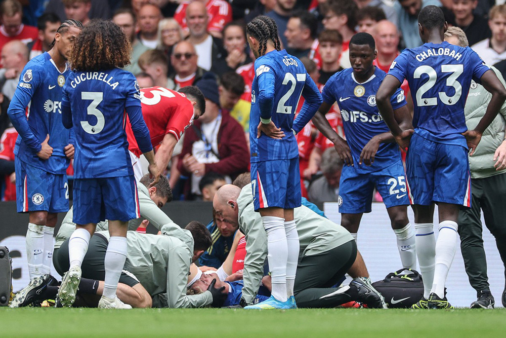 Teammates and officials gather around as Chelsea's English striker #55 Jesse Derry (on ground L) is checked after being injured during the English Premier League football match between Chelsea and Nottingham Forest at Stamford Bridge in London on May 4, 2026. (Photo by Adrian Dennis / AFP)