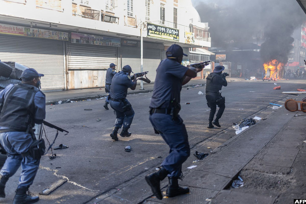 South African Police Service (SAPS) officers fire rubber bullets as clashes erupt between protesters and foreign nationals in Durban on October 8, 2026.