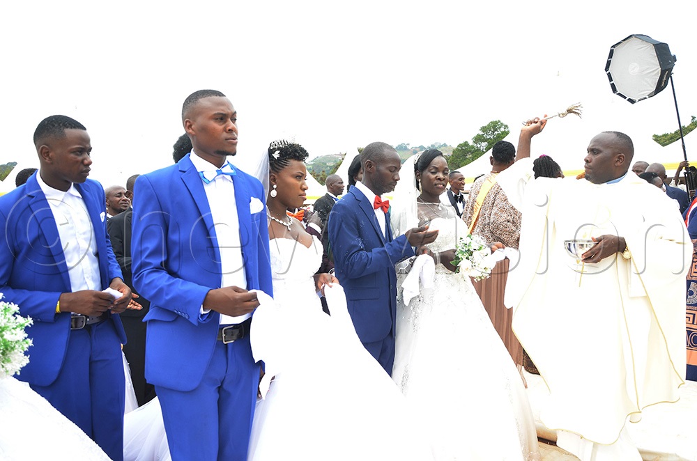  Fr Basil Fredrick Mirundi blessing the couples after tying the knot at St Padre-Pio Catholic Parish Kabulamuliro on Saturday in the mass wedding organised by Entebbe Deanery Catholic Charismatic Renewal. (Photo by Juliet Anna Lukwago)