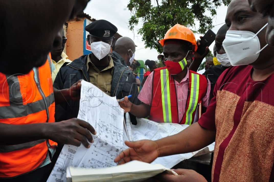 Lukwago (right) and engineers verifying some documents.