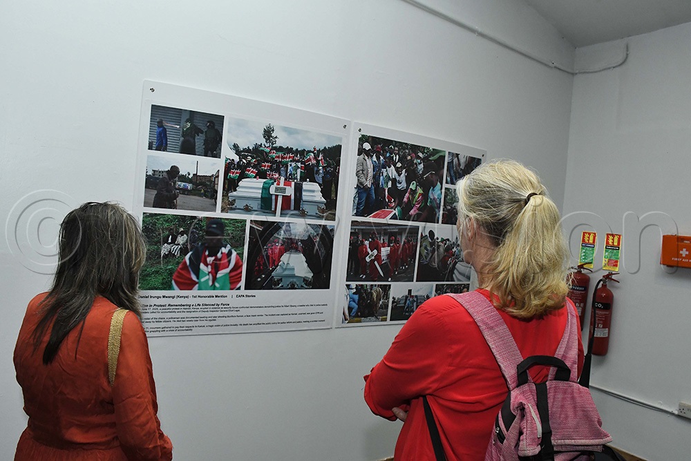 Photography enthusiasts looking at the incredible photos took by Kenya's Daniel Irunga Mwangi. (Photo by Ignatius Kamya)