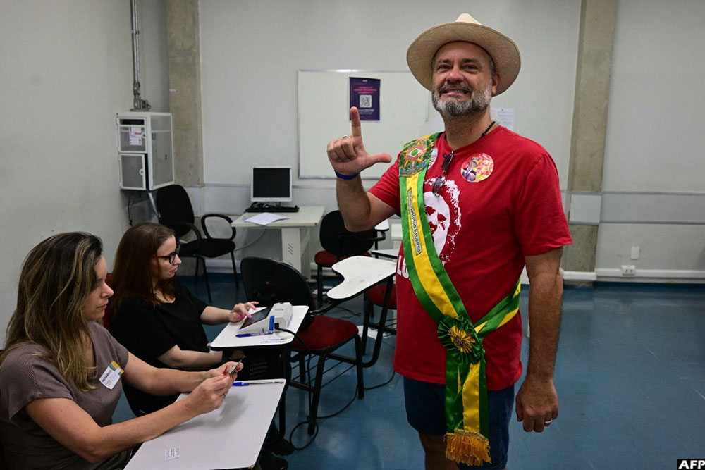 A supporter of Brazil's President and presidential candidate Luiz Inacio Lula da Silva poses as he votes at a polling station during the presidential runoff election in Brasilia