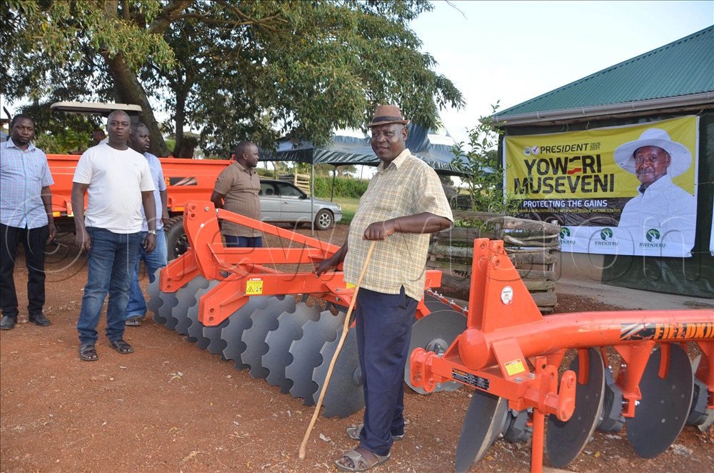 Martin Kananura-the director of Rwenjeru Agro-Tourism, Demo and Training Farm (2nd from right holding a stick) showing the tractor to the Vision group team he hosted at his farm on Saturday.