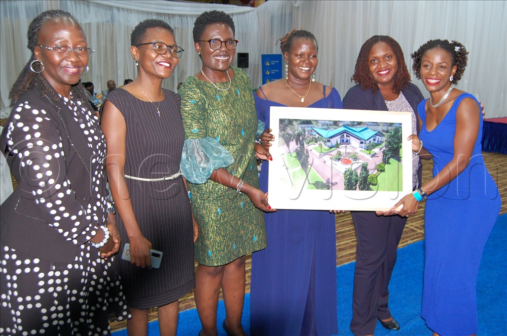 Dr. Zam Nalule (right) shares a photo moment with her friends after buying the portrait of the proposed classroom block. Thiis was during the fundraisong dinner of Mount St. Mary's College Namagunga at Hotel Africana in Kampala on Thursday, December 4.